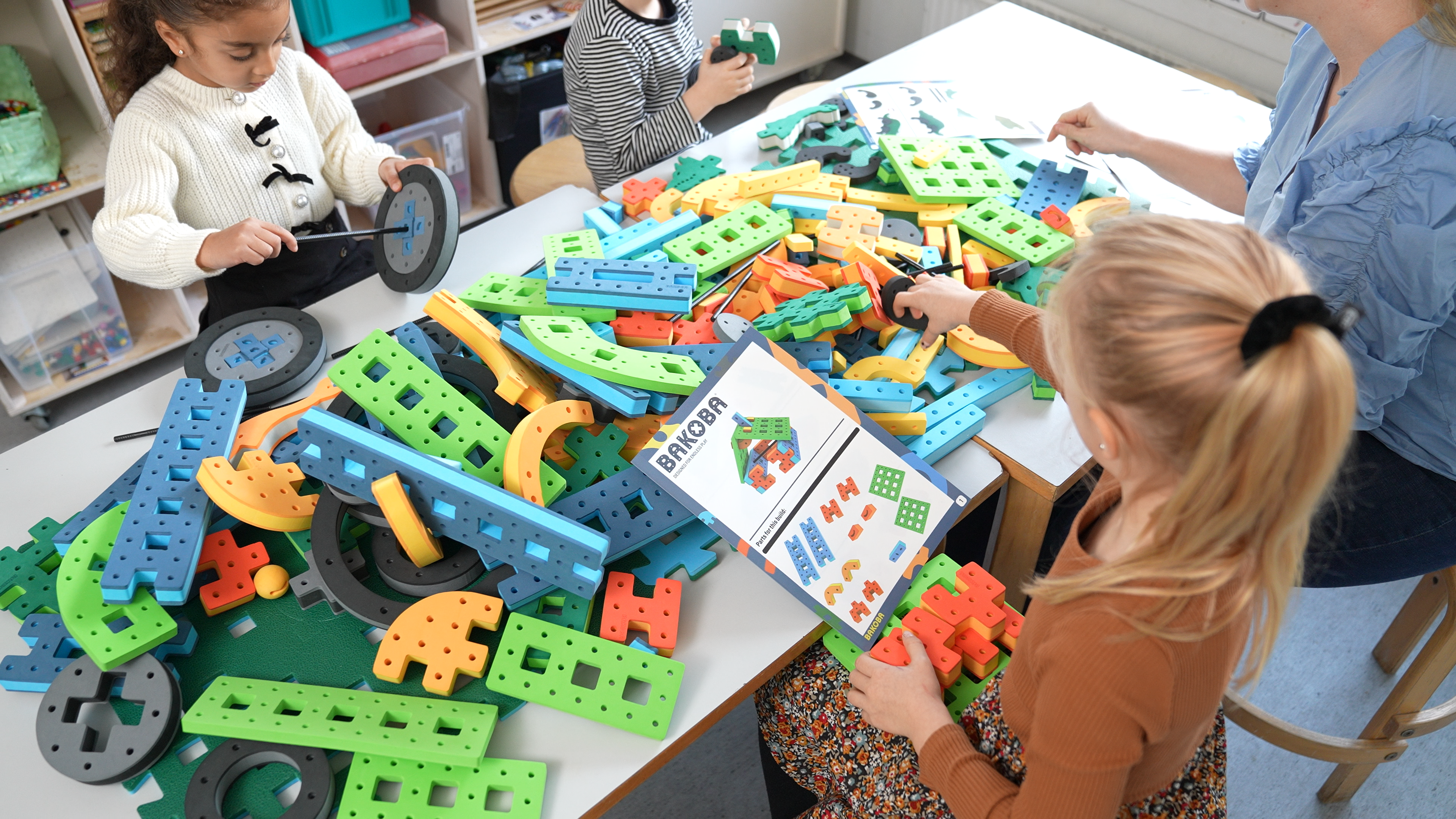 everal children collaborating on a large BAKOBA construction in a kindergarten classroom